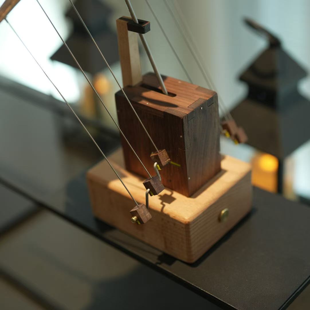 Wooden mechanical model on a reflective surface with blurred background